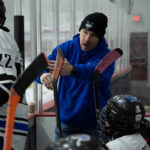 A group of athletes skating with helmet on the rink