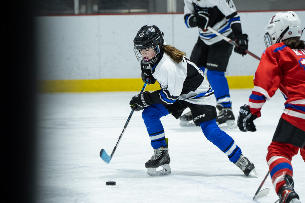 A group of athletes skating with helmet on the rink