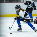 A group of athletes skating with helmet on the rink