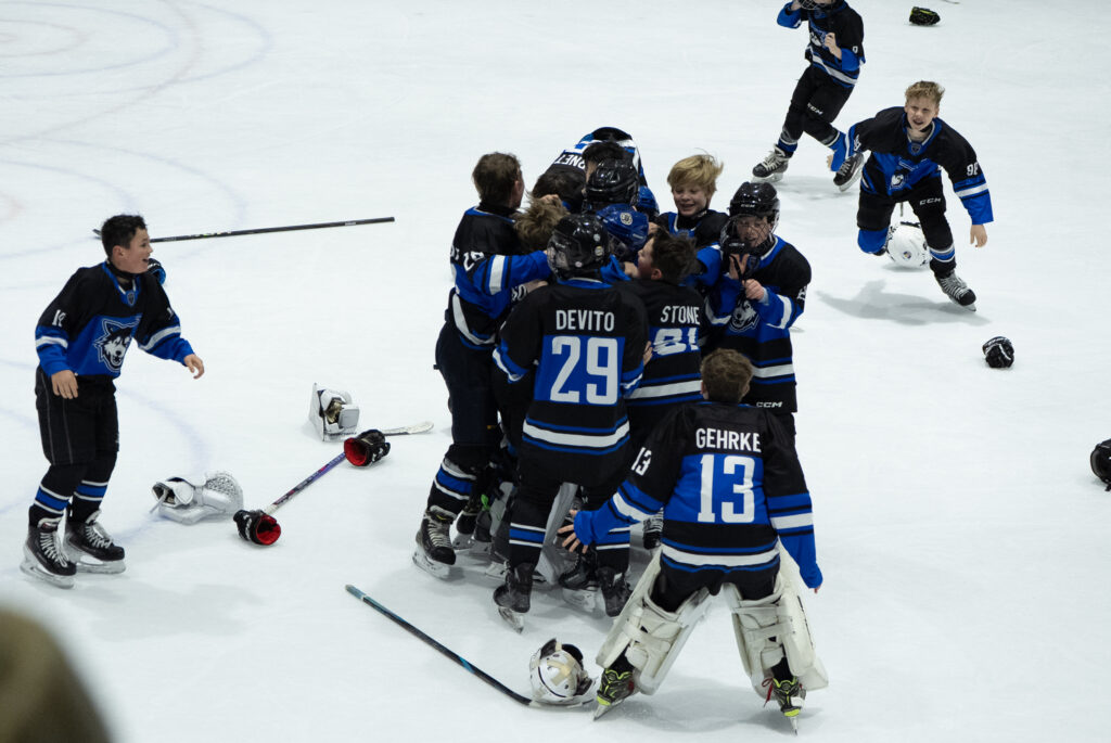 A group of athletes skating with ball and helmet on the rink