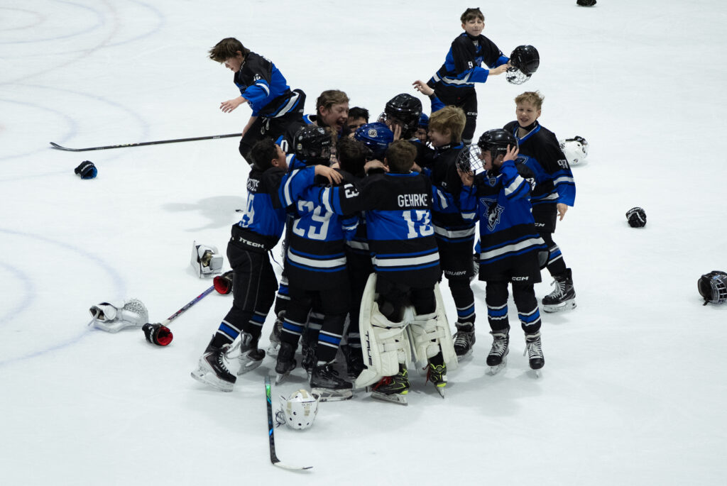 A group of athletes competing field hockey with helmet