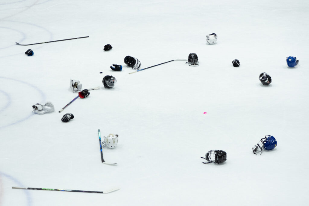 Two athletes skating with helmet on the rink