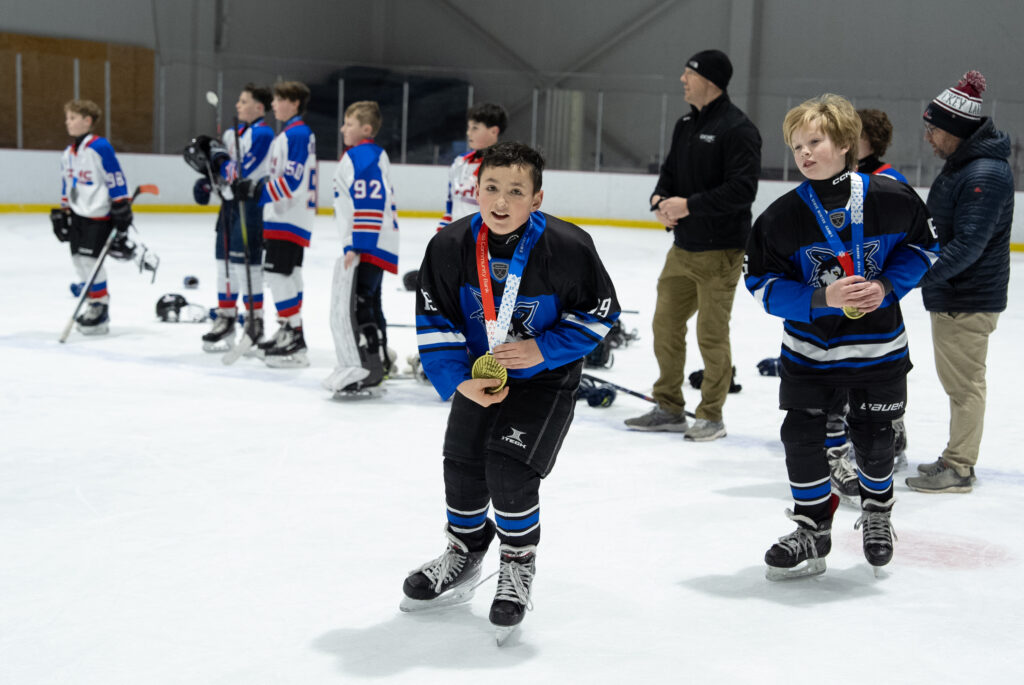 A group of athletes competing field hockey with helmet