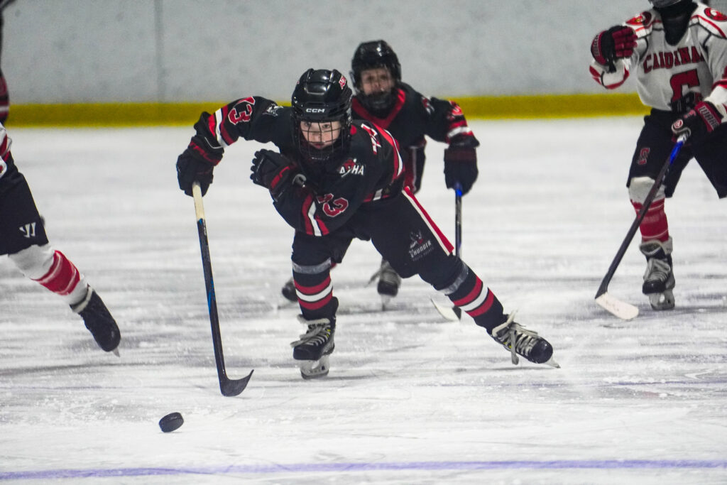 A group of athletes skating with helmet on the rink