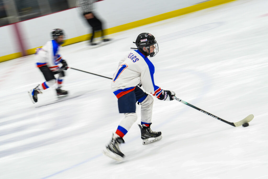 A group of athletes skating with helmet on the rink