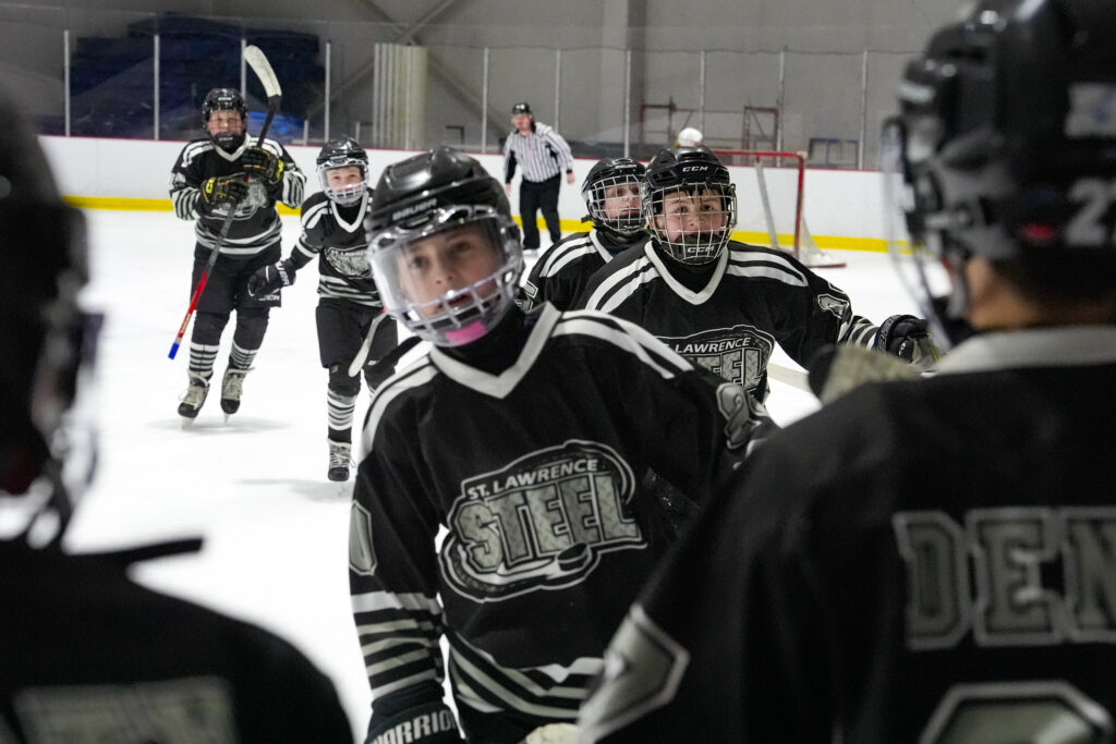 A group of athletes competing field hockey with helmet