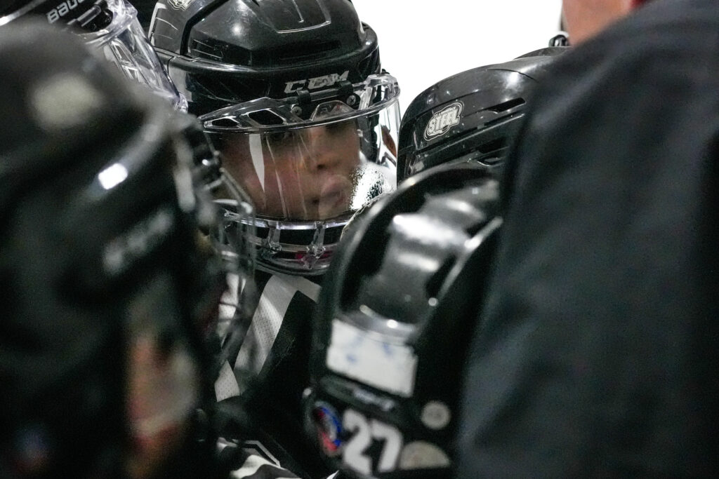 Two athletes playing football with helmet on the field