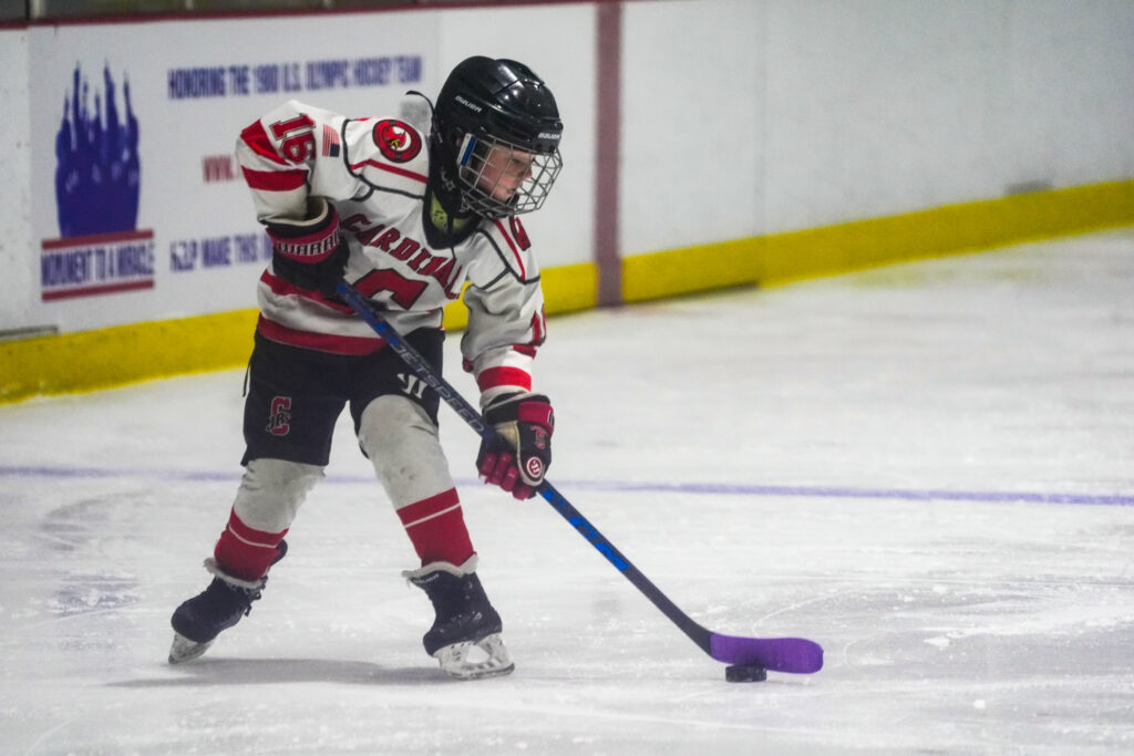 An athlete skating with helmet on the rink