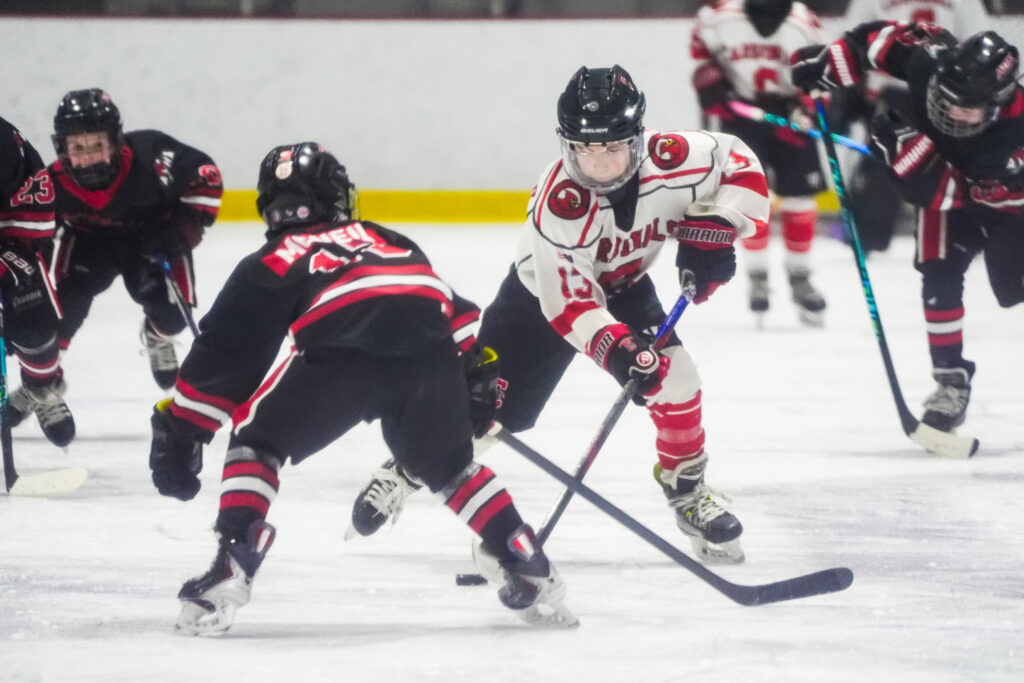 A group of athletes competing field hockey with helmet