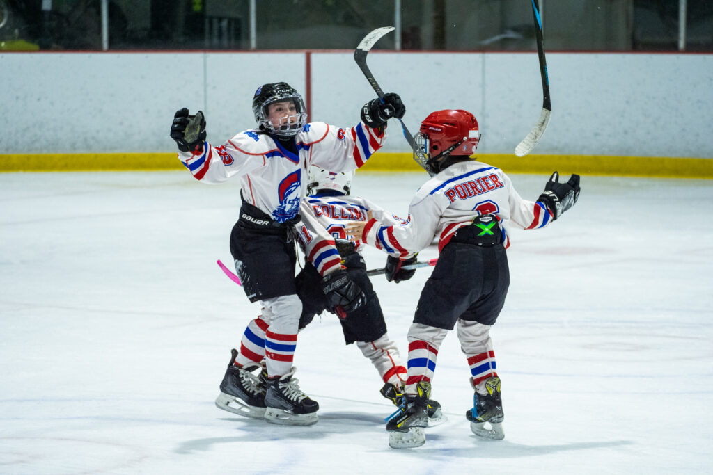 Two athletes skating with helmet on the rink