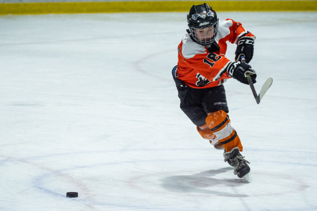An athlete skating with helmet on the rink