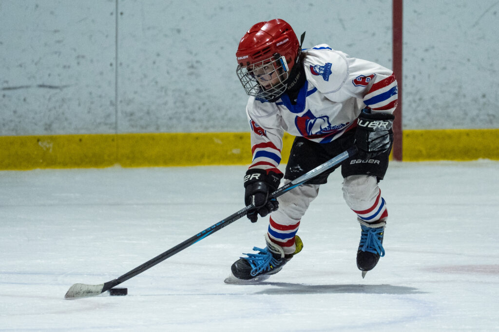 An athlete skating with helmet on the rink