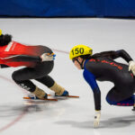 Two athletes skating with helmet on the rink