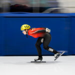 An athlete skating with helmet on the rink