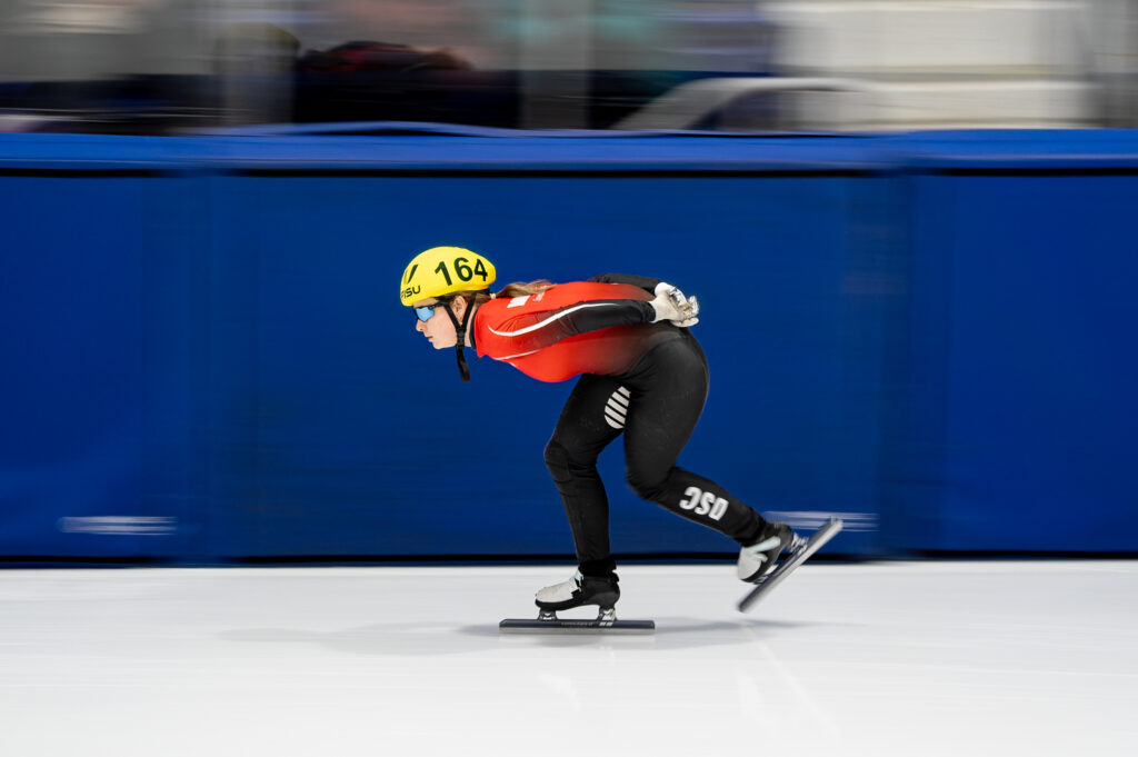 An athlete skating with helmet on the rink