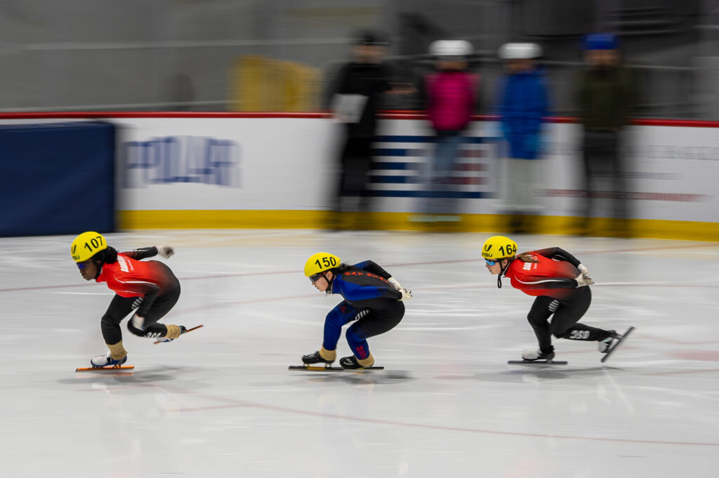 A group of athletes skating with helmet on the rink