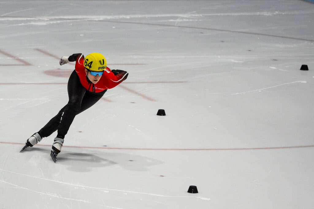 An athlete skating with helmet on the rink