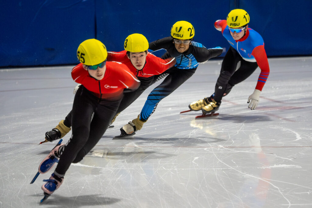 A group of athletes skating with helmet on the rink