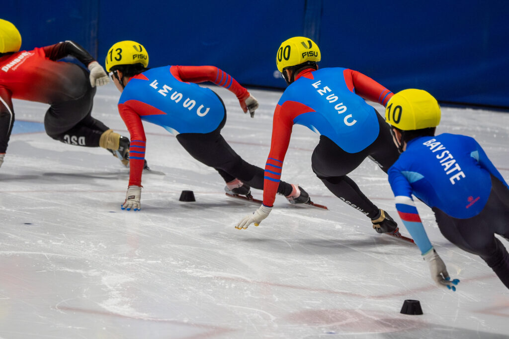 A group of athletes skating with helmet on the rink
