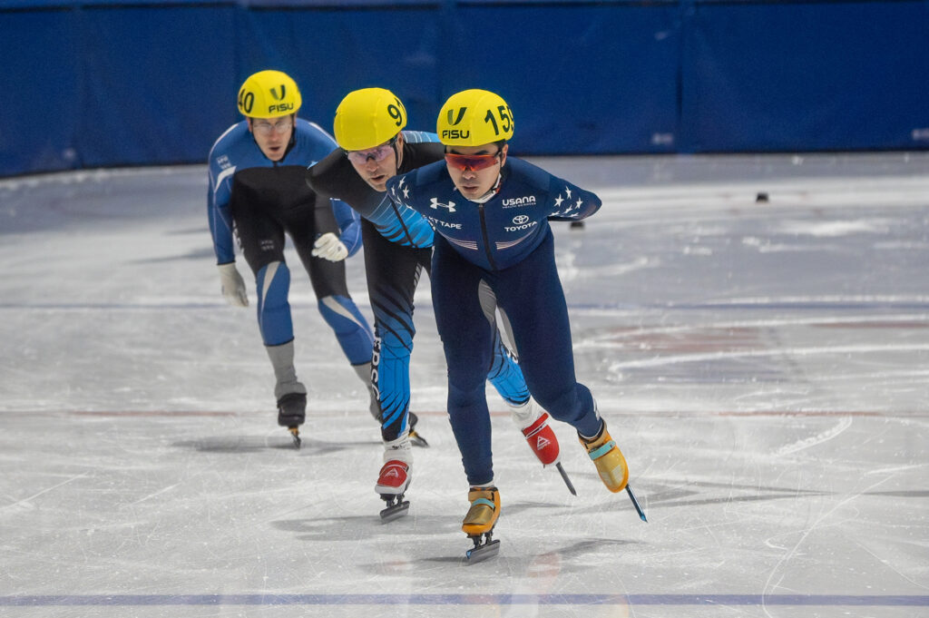 Two athletes skating with helmet on the rink