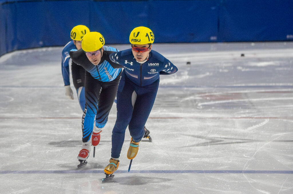 A group of athletes skating with helmet on the rink