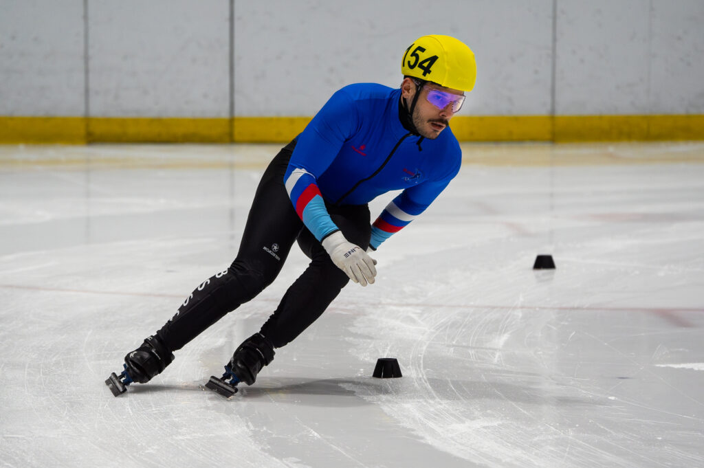 An athlete skating with helmet on the rink