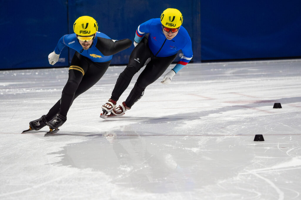 Two athletes skating with helmet on the rink