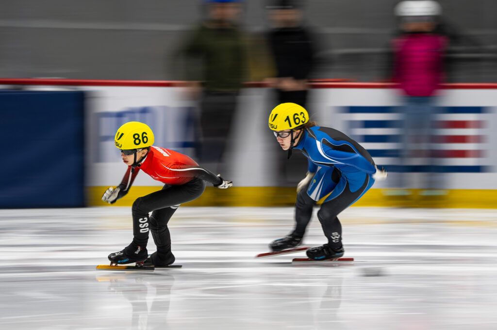 A group of athletes skating with helmet on the rink