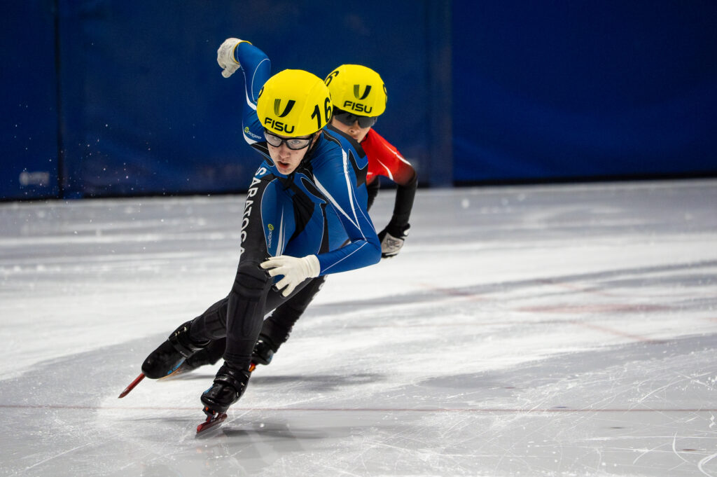 Two athletes skating with helmet on the rink