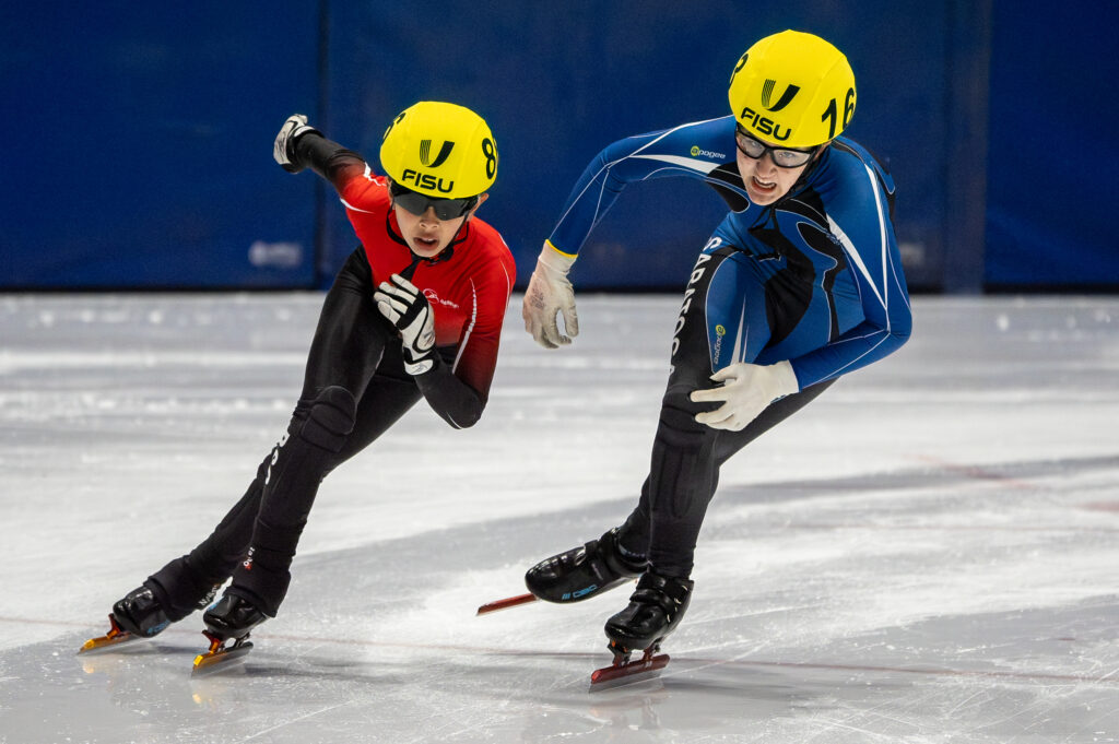 Two athletes skating with helmet on the rink