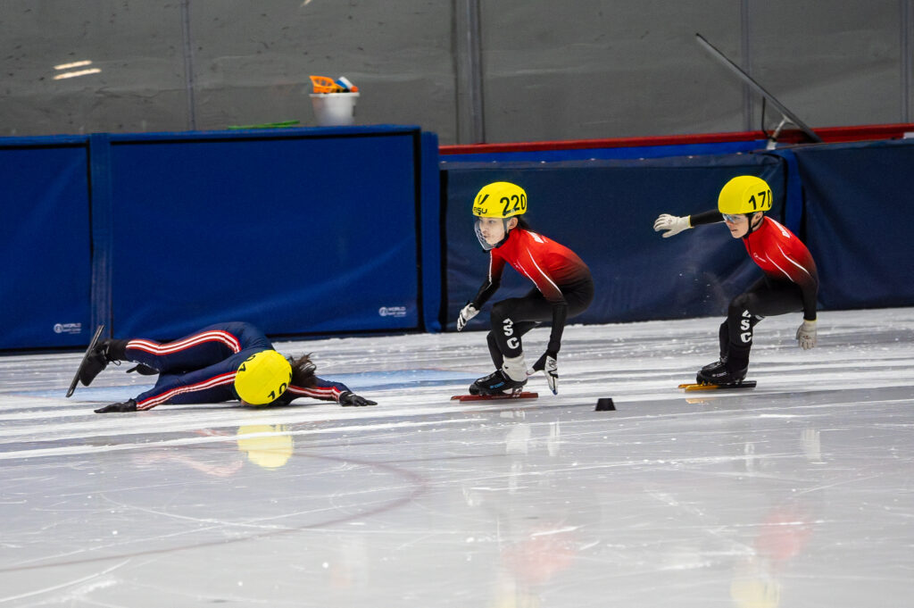 A group of athletes skating with helmet on the rink