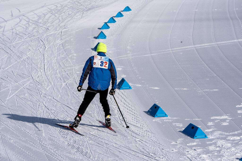 An athlete skiing with helmet in the snow