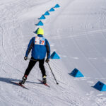 An athlete skiing with helmet in the snow